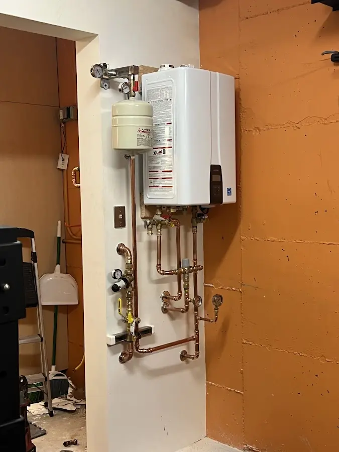 Plumbing technician inspecting water heater connections in Holtville